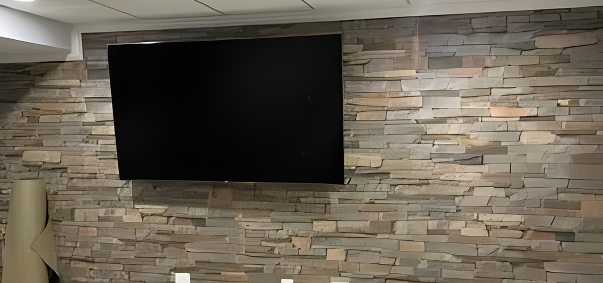 Wall-mounted TV on stone accent wall.